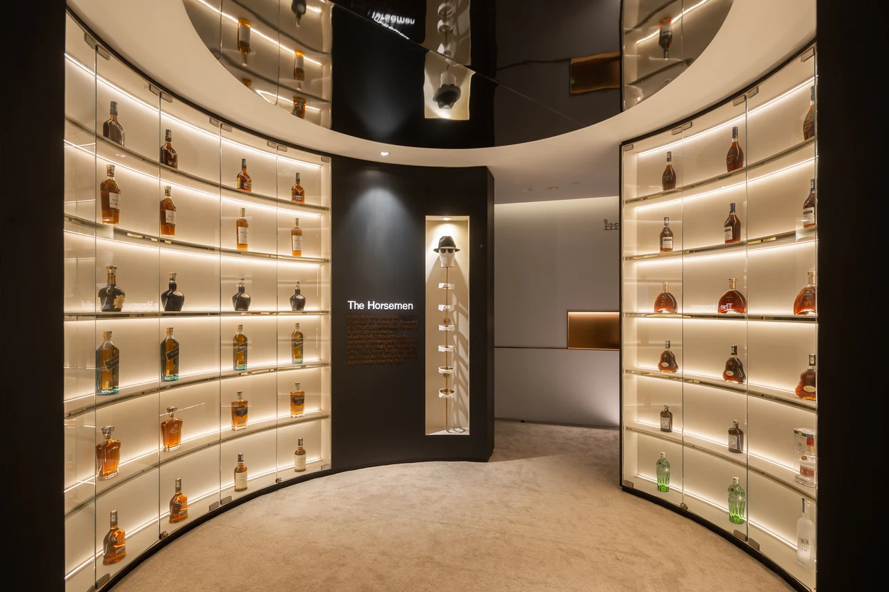 Curved illuminated bottle shelving creates the most distinctive immersive composition.