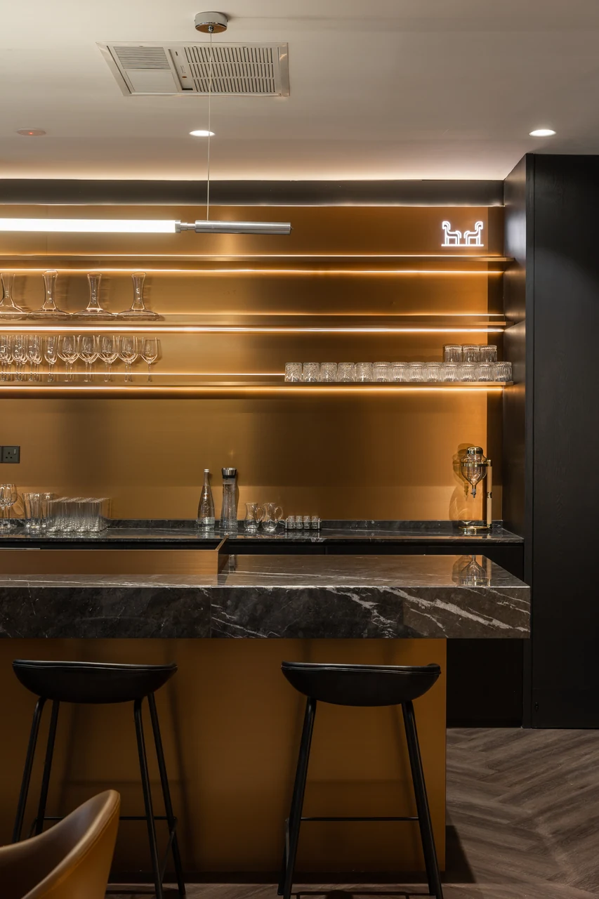 Illuminated bar with veined stone and stools