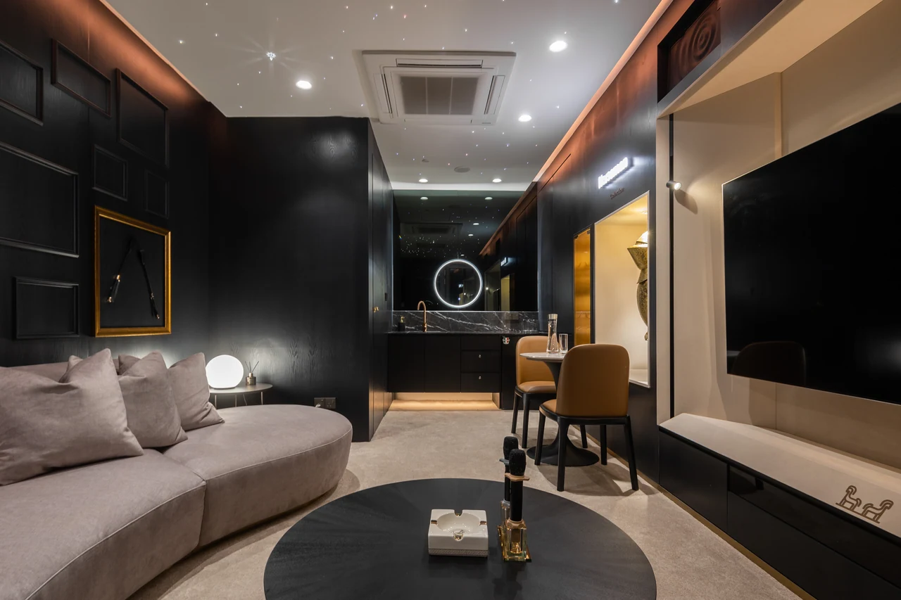Dark private lounge with illuminated ceiling and framed artwork