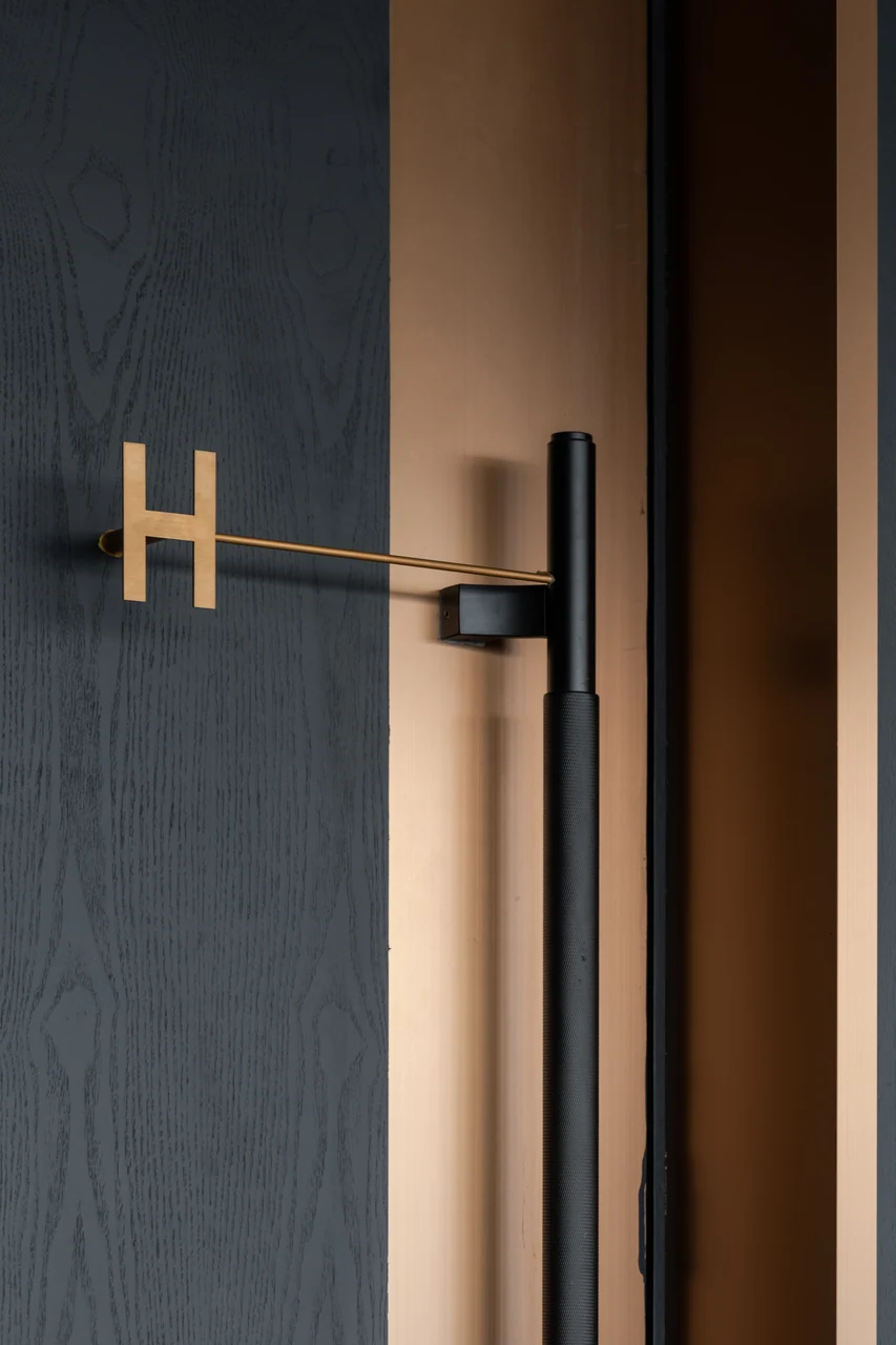 The monogrammed door and long handle provide a precise threshold detail.