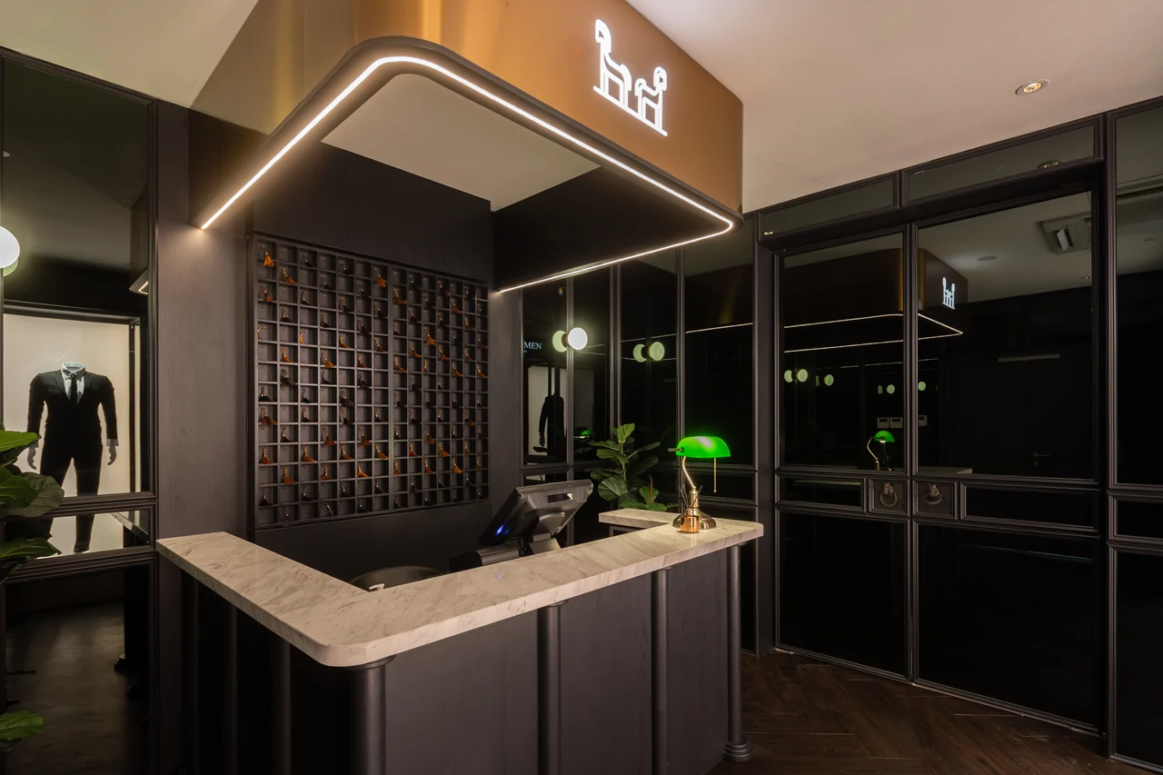The reception desk and outlined ceiling establish arrival and the frame motif.