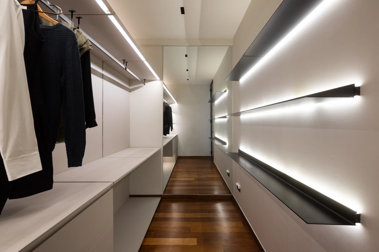 The wardrobe’s parallel light lines create depth and reveal the fitted storage.