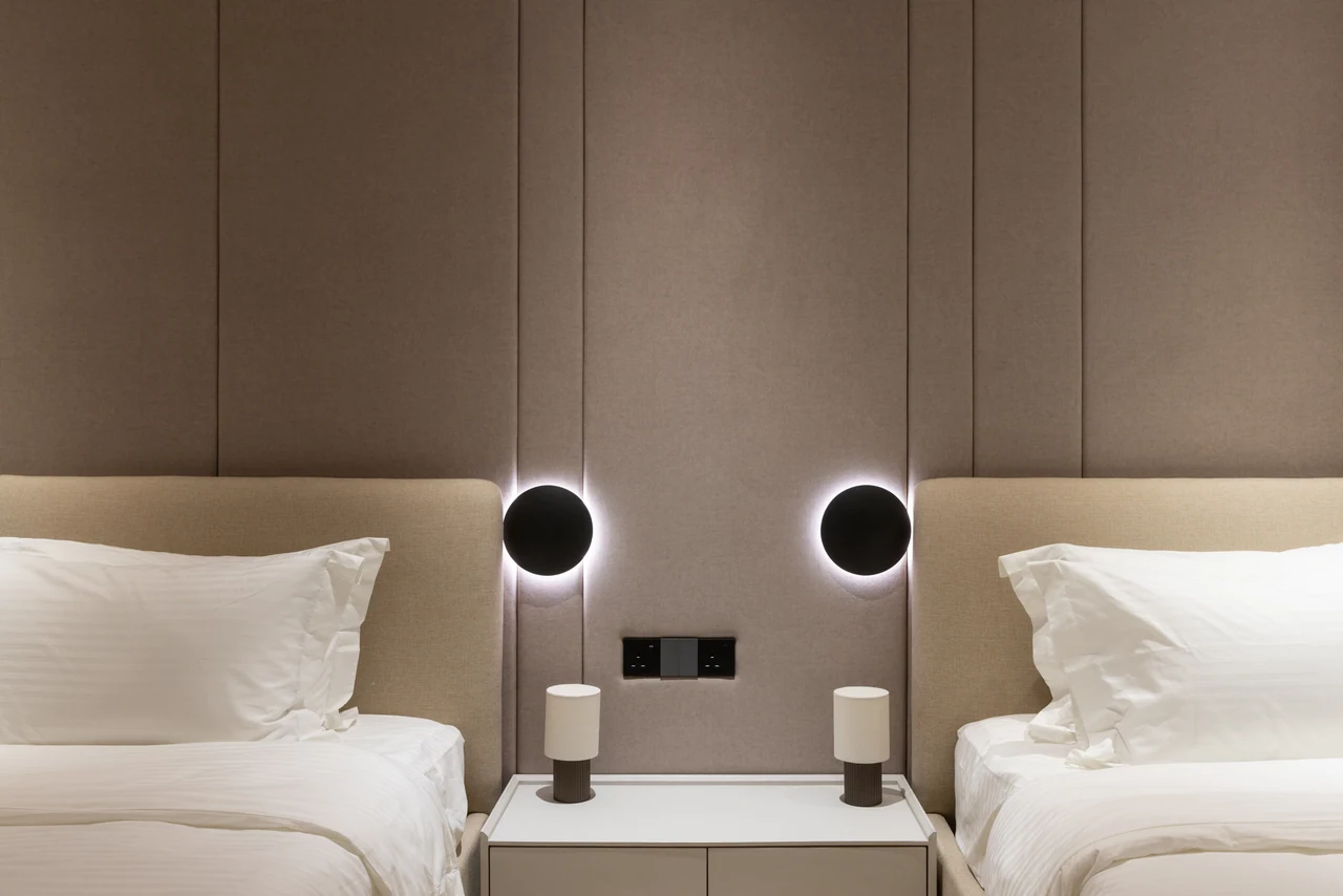 Paired circular bedside lights supply a graphic, symmetrical pause.