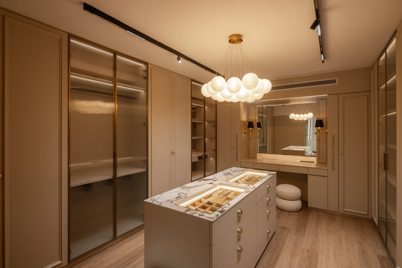The glowing wardrobe island introduces a richer, enclosed mood.