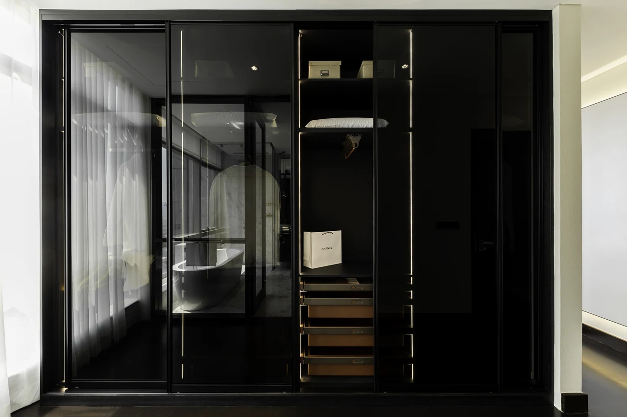 Dark glazed wardrobe frames add depth and tonal contrast.