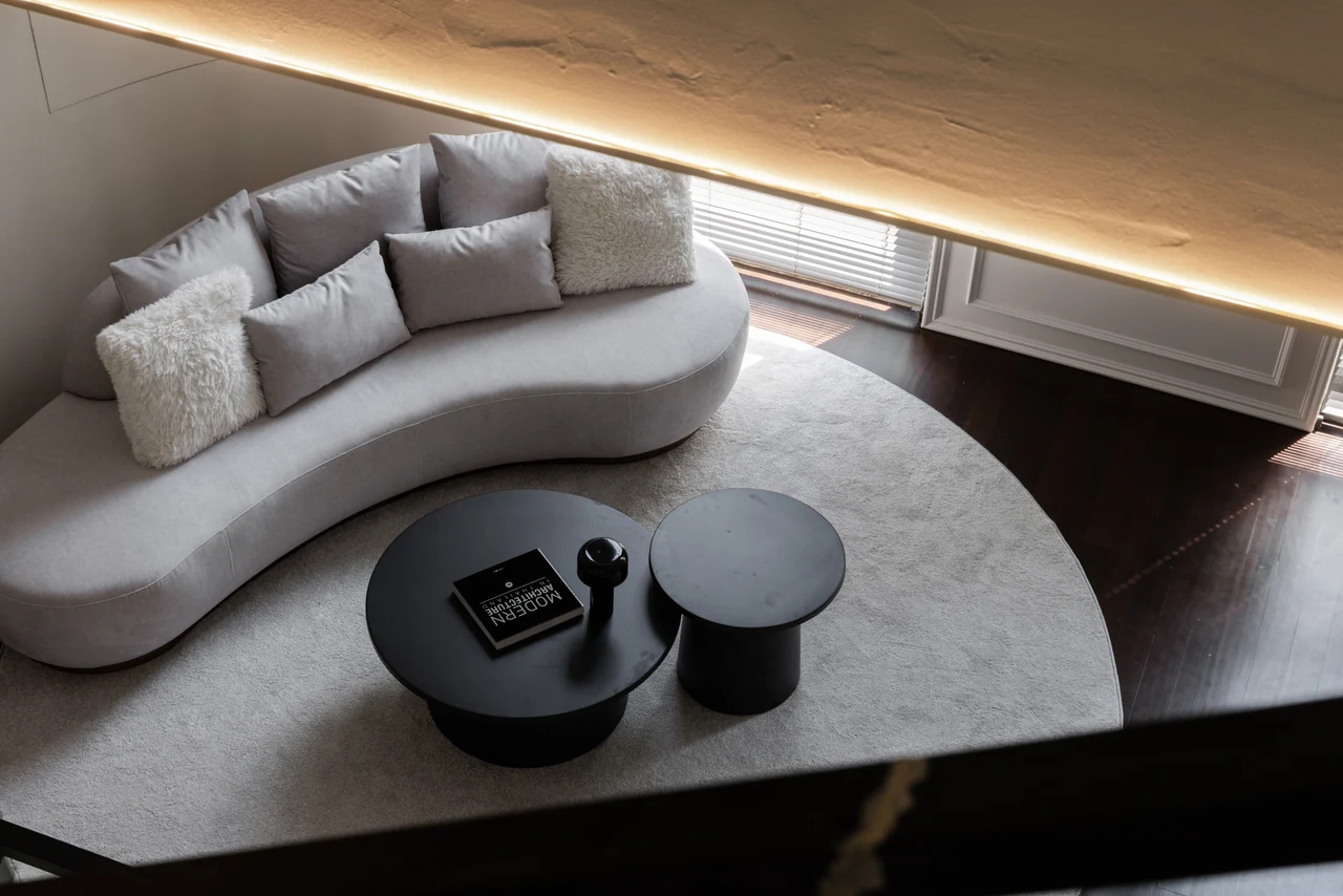 The elevated view makes the sofa, rug and circular tables read as a composed plan.